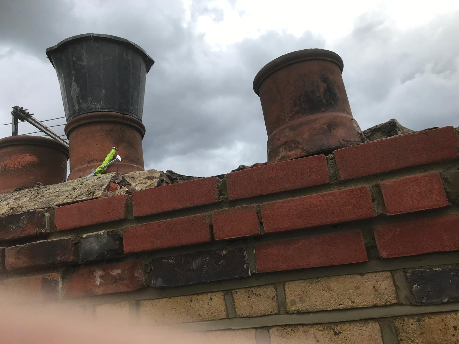 Chimney pot and flaunching repair with fresh mortar bedding and lead tray flashing on residential rooftop