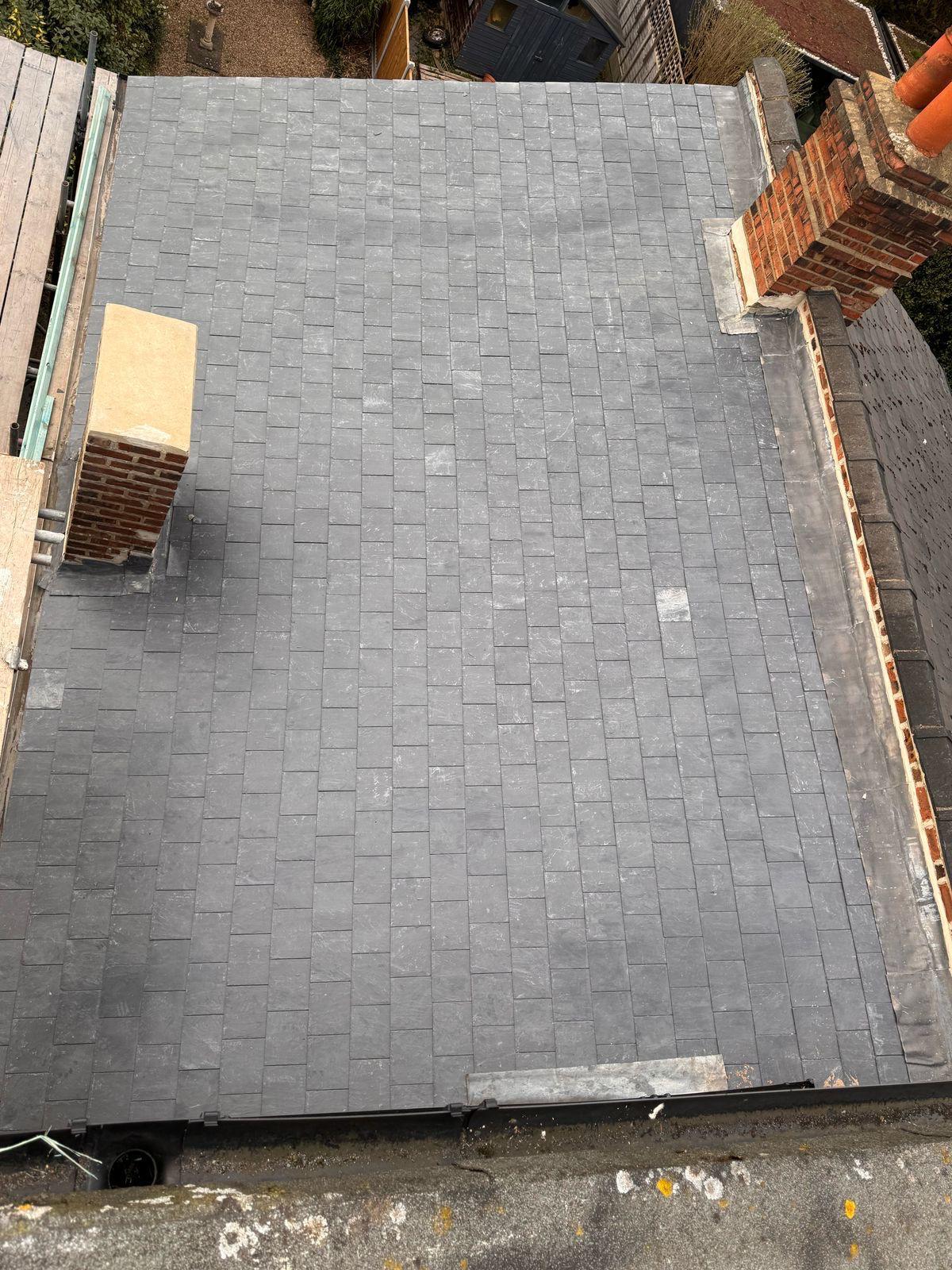 Completed natural slate roof from above showing full area with chimneys and new lead flashings on Victorian Hampstead property